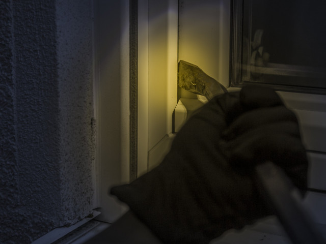 Burglar breaking through a window