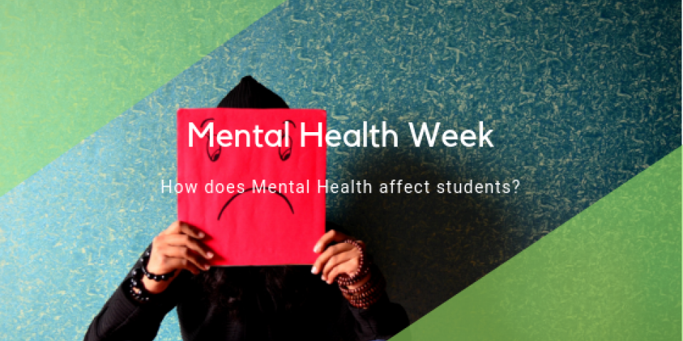 Man holding up a sad face card for mental health week